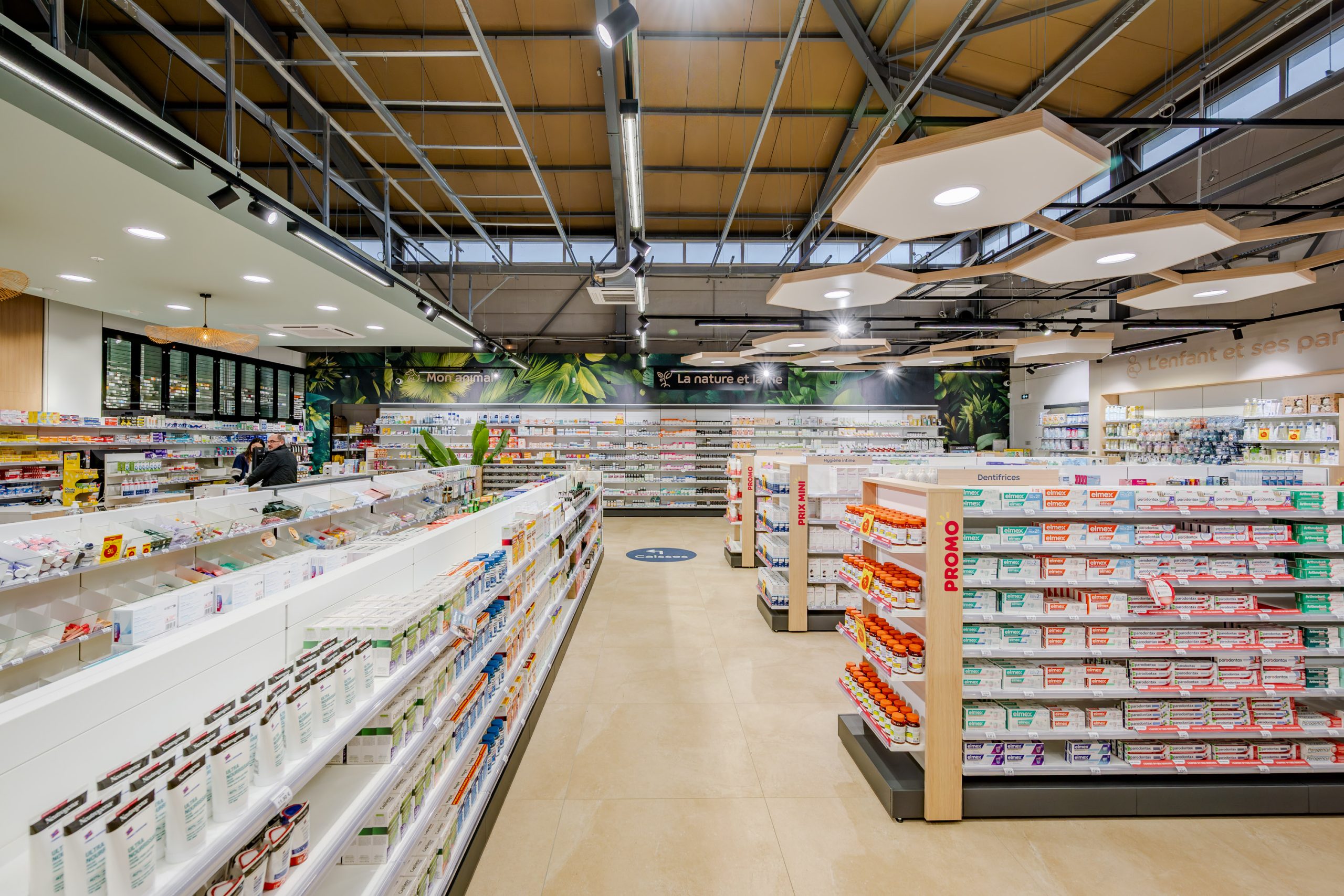Vue globale de la Grande Pharmacie avec plafond en nid d'abeille et matériaux nobles comme le bois.