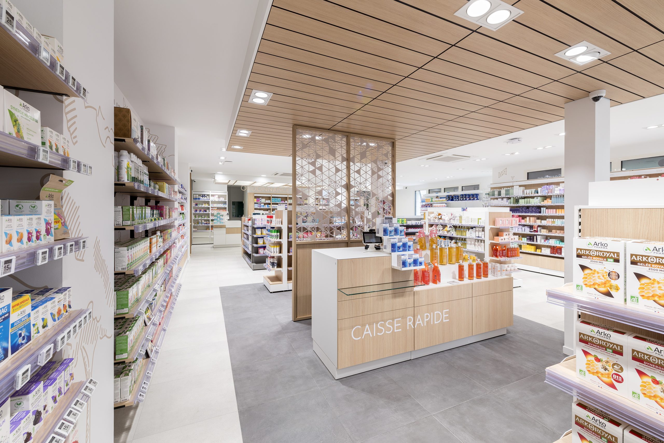 Espace nature, caisse rapide. Mobilier et plafond en bois, sur-mesure. Un espace central au coeur de la pharmacie Beauvais.