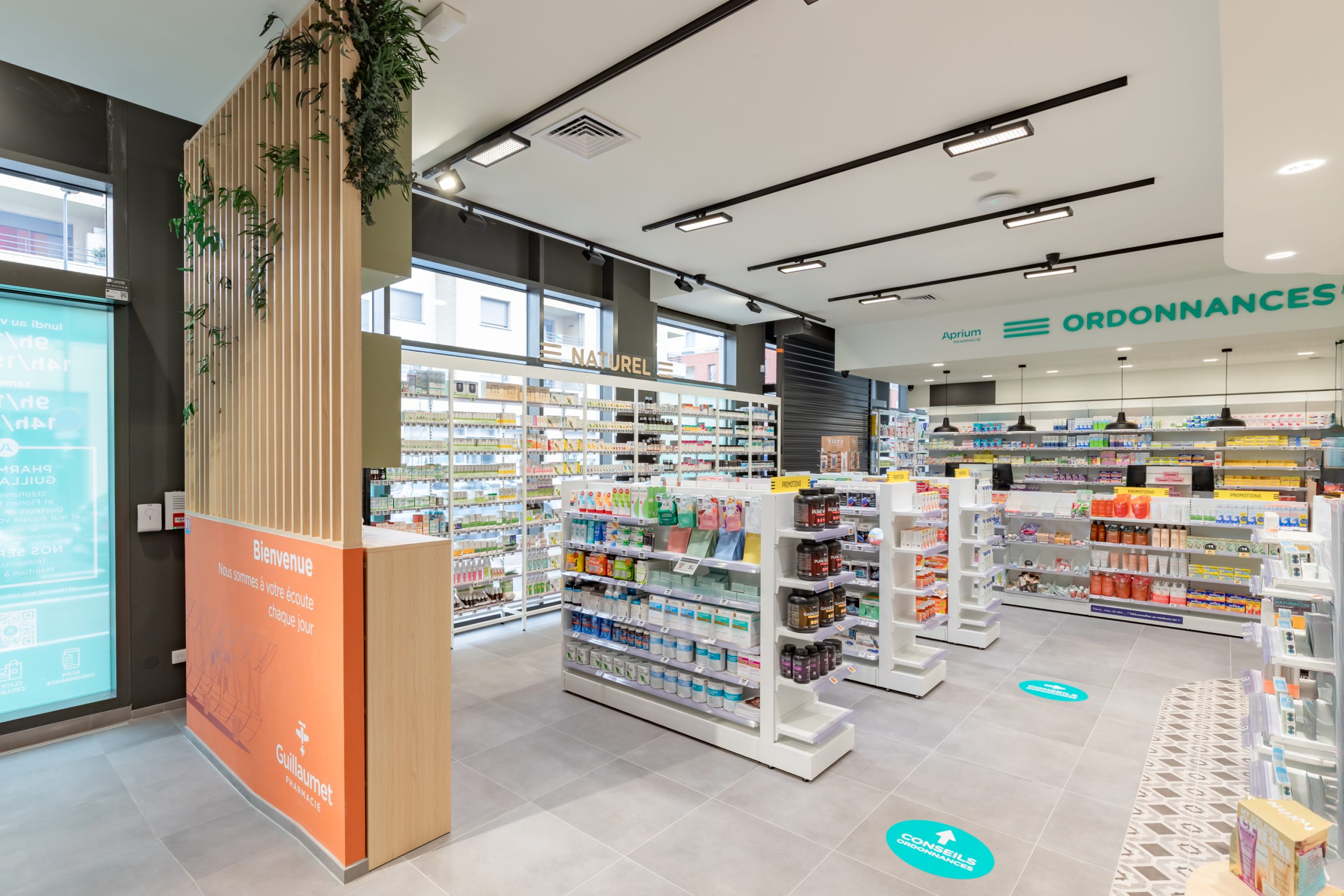 Vue de l'entrée de la pharmacie Guillaumet avec l'espace comptoir et espace naturel.