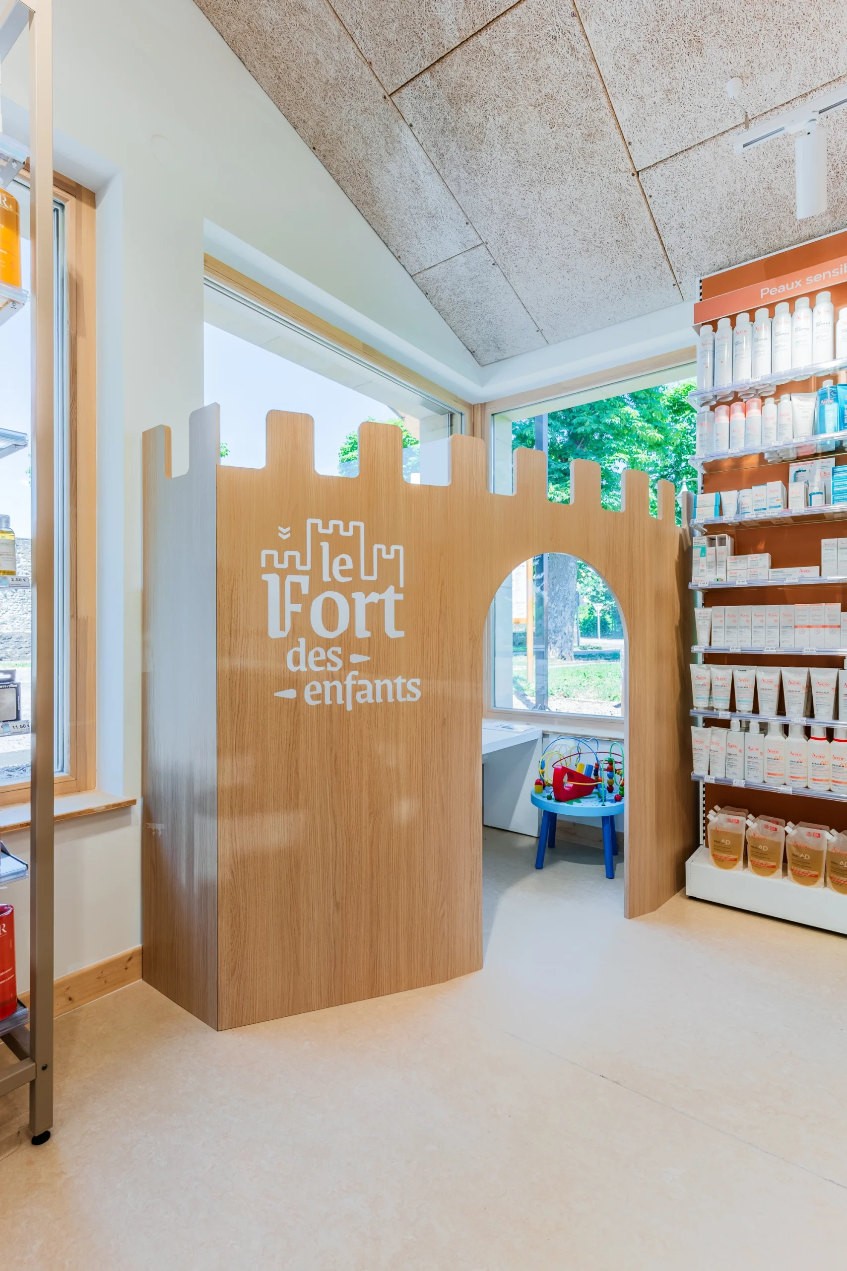Espace enfants ludique de la Pharmacie de Rodemack avec mobilier original en bois.
