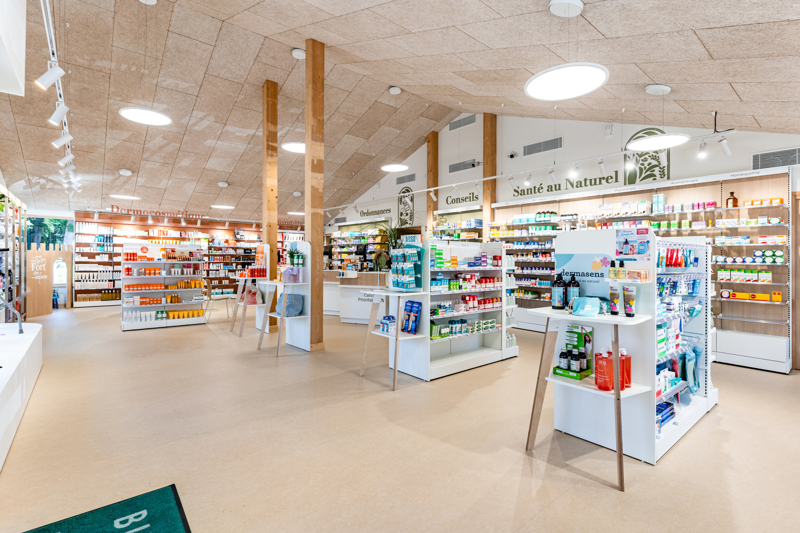 Vue centrale de l'espace de vente de la Pharmacie de Rodemack avec îlots et rayons.