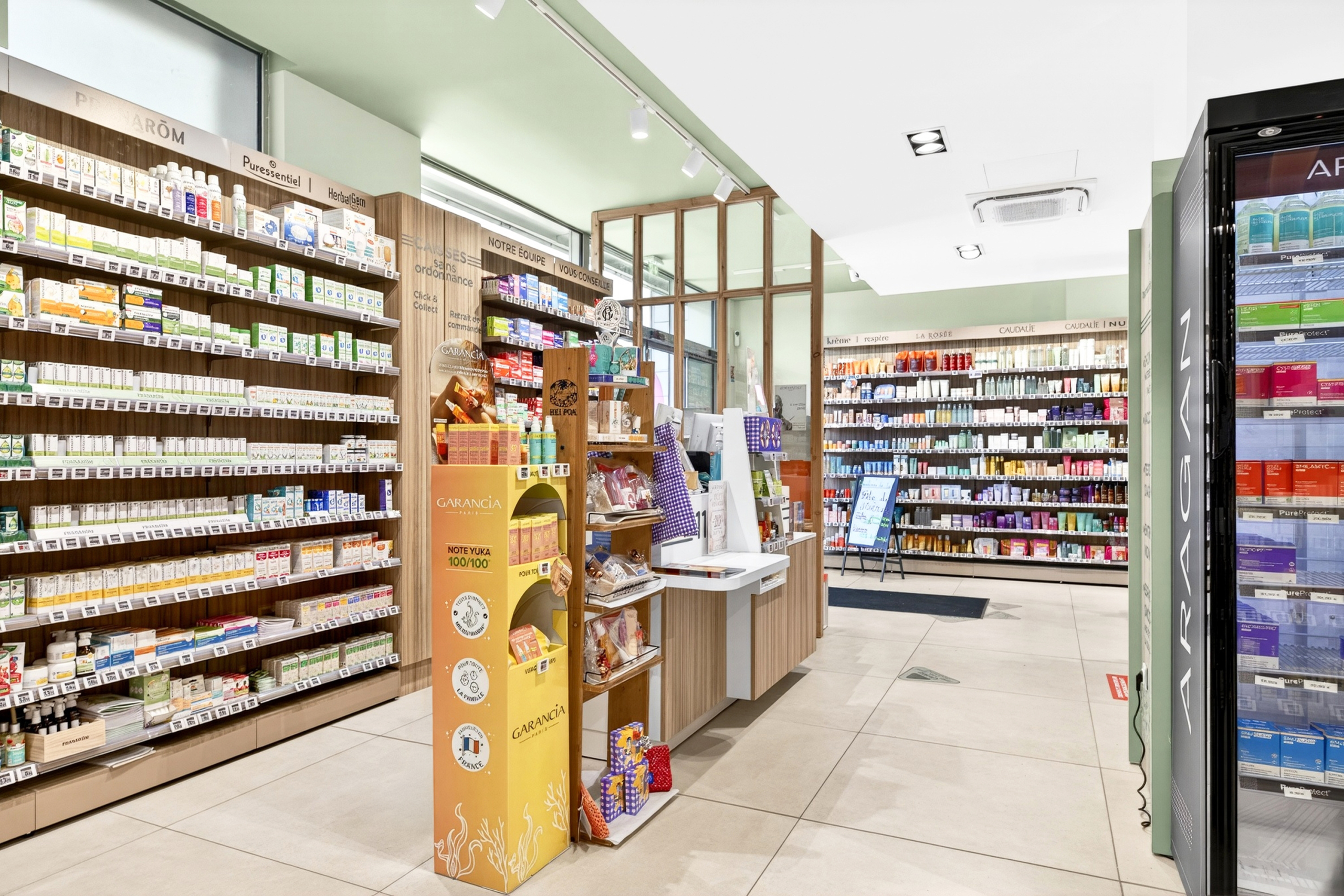 Allée centrale et rayons médicaments de la Pharmacie Les Garennes.
