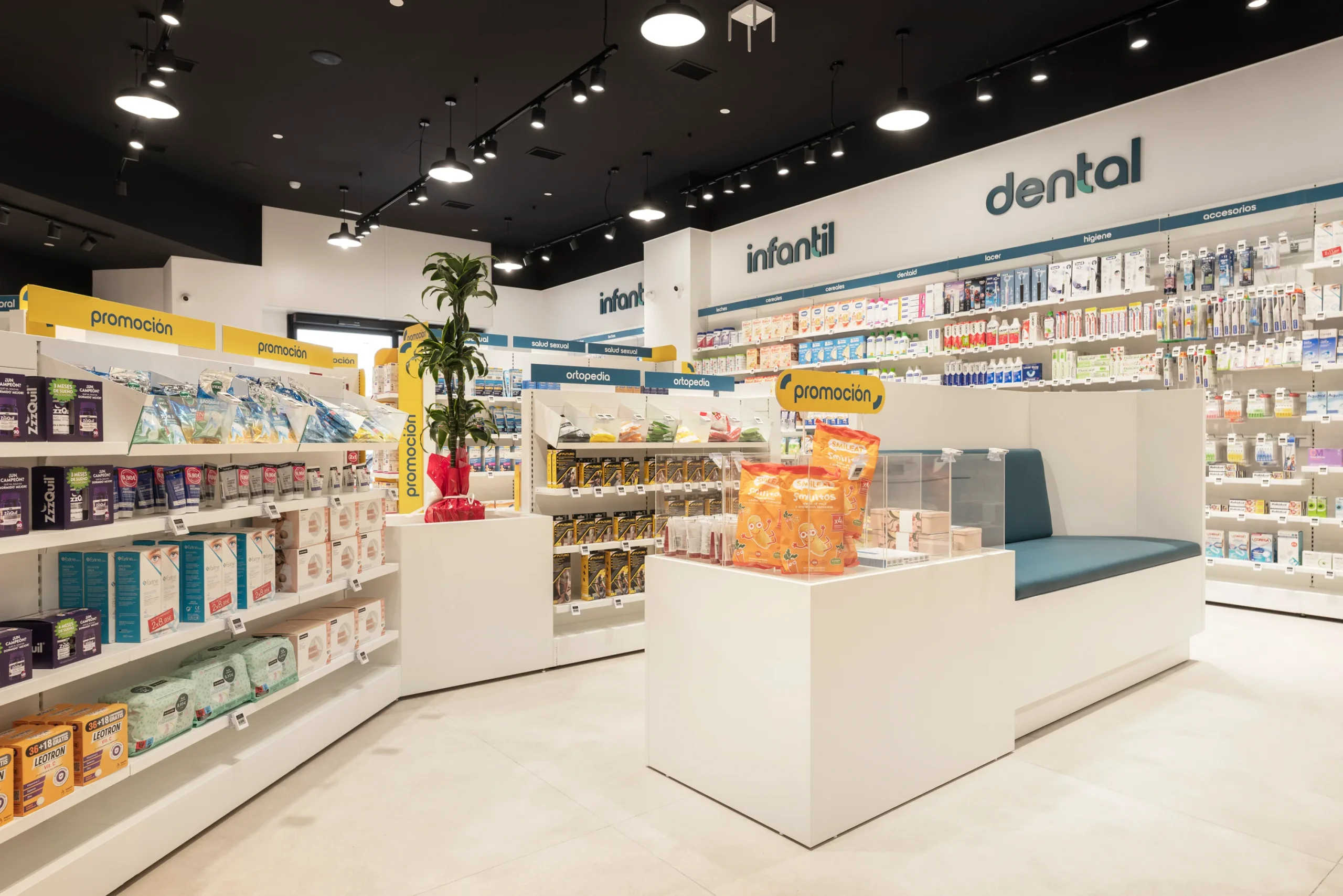 Zona central de farmacia con banqueta de descanso y lineales de ortopedia e infantil en Tu Pharma Segovia.